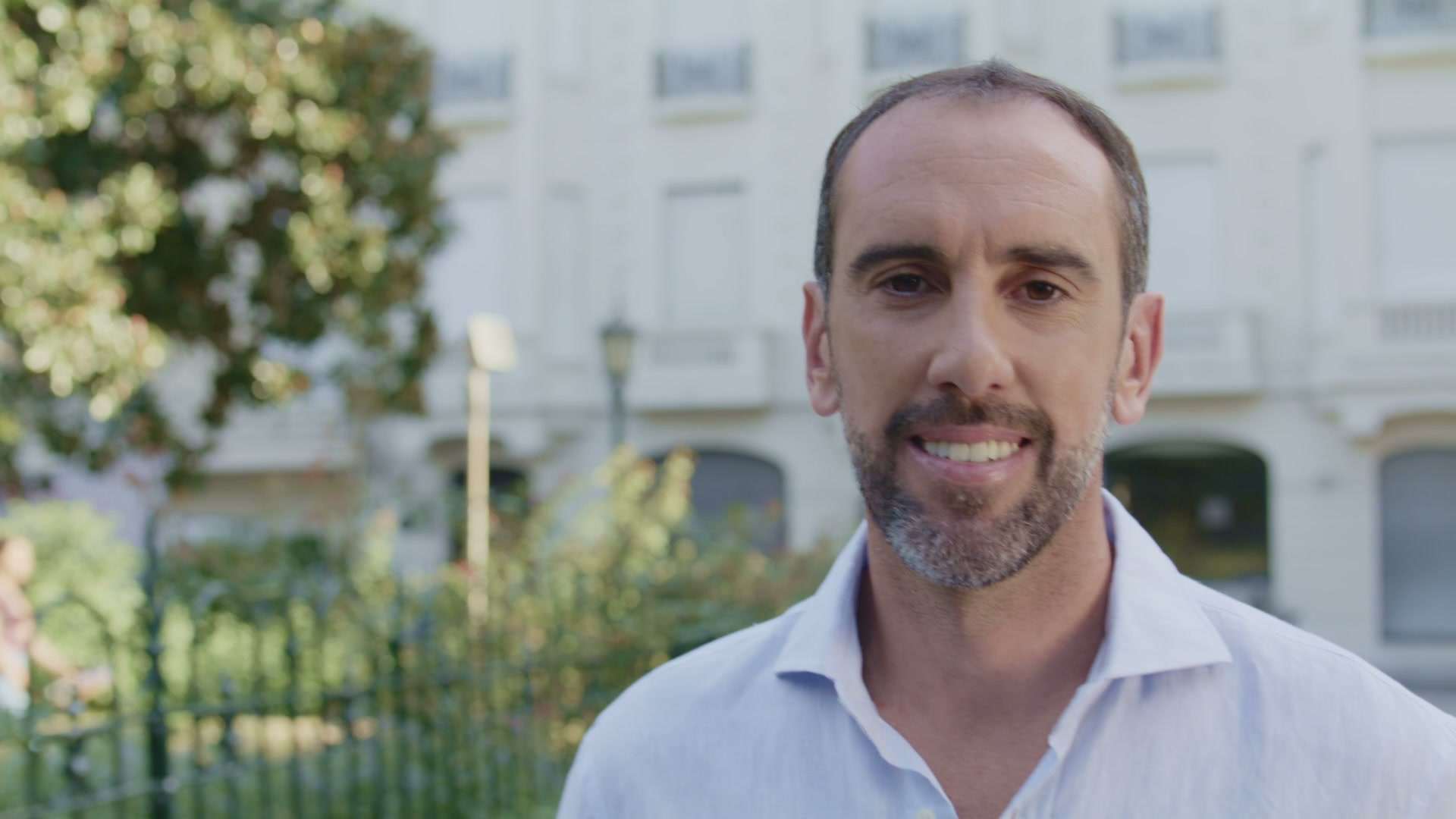 Diego Godín sonriendo frente a un edificio antiguo con reja