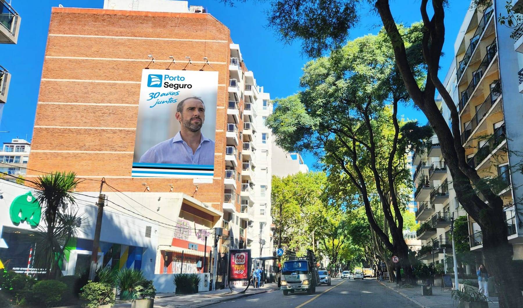 Montaje del gráfico «30 años juntos» con Diego Godín sobre la medianera de un edificio de ladrillo